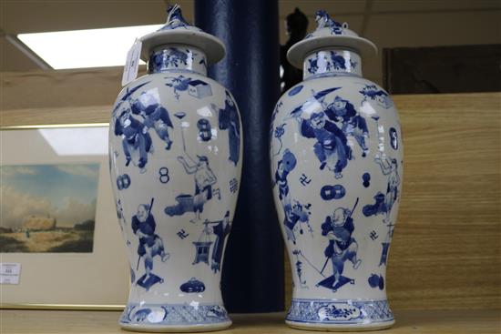 A pair of 19th century Chinese blue and white baluster vases and covers, decorated with figures, 37cm